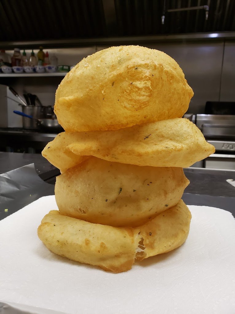Golden puffed hot bhature stack in the kitchen