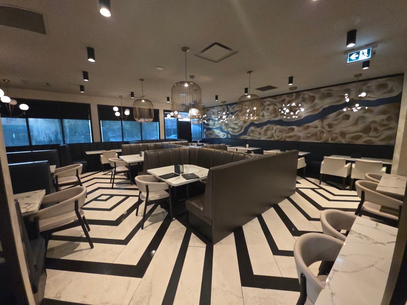 Upscale dining room hall with circular leather seating and modern ceiling fixtures