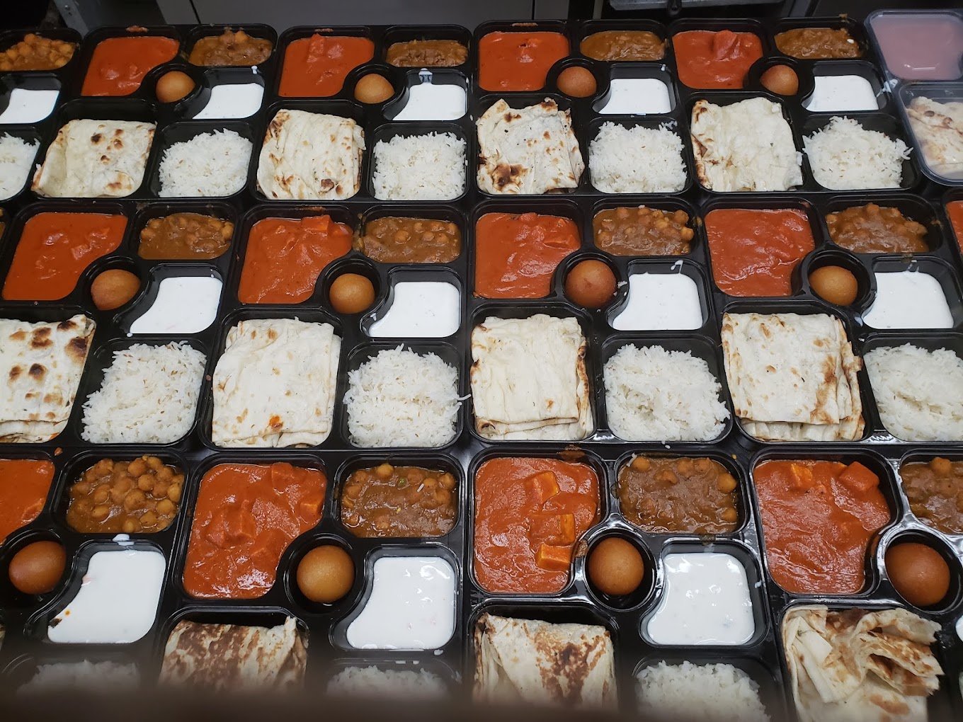 Spice of Punjab packaged thali catering boxes with fresh curries and naan
