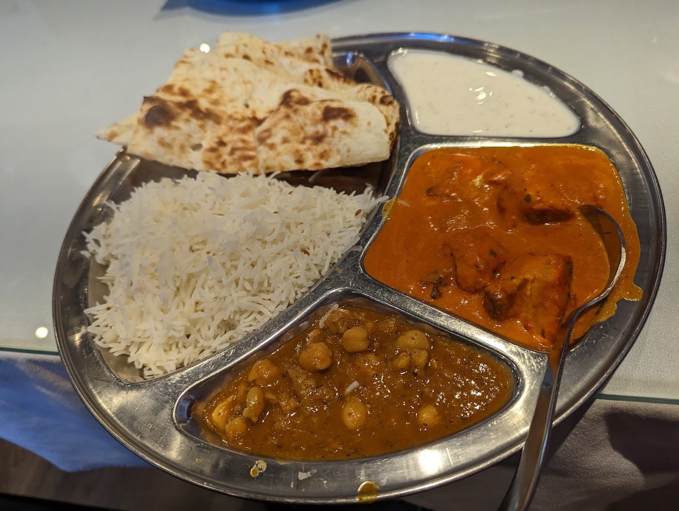 Thali lunch special with butter chicken, basmati rice, naan, chana masala and raita