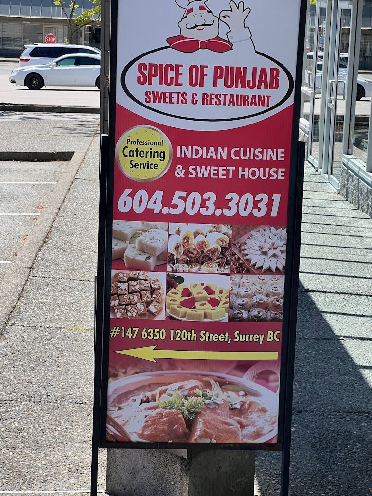 Outdoor plaza directory signage pointing to Spice of Punjab