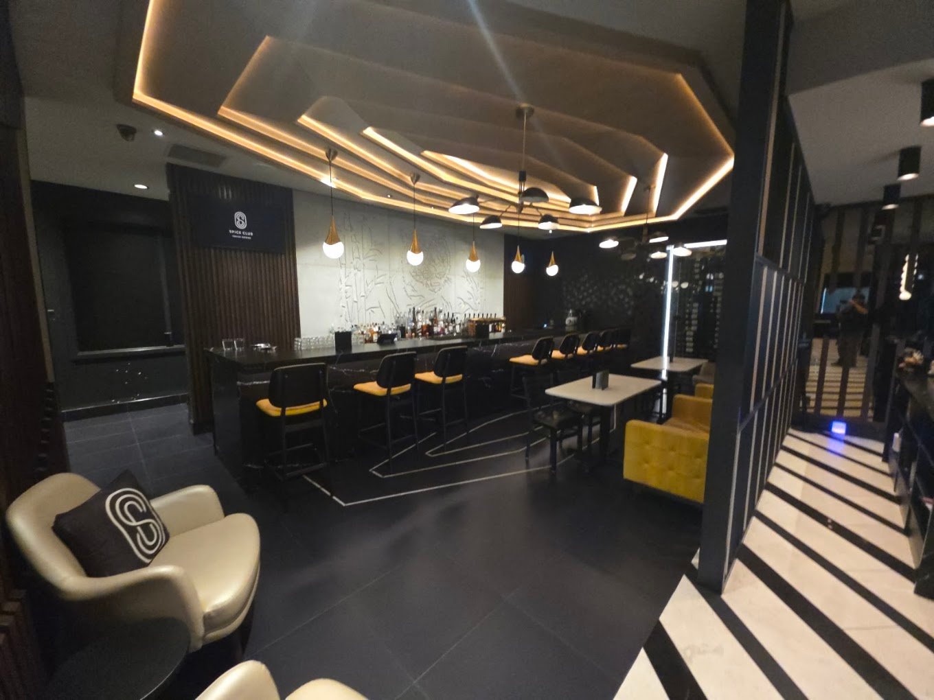 Lounge bar area with contemporary acoustic wood slatted walls and bar chairs