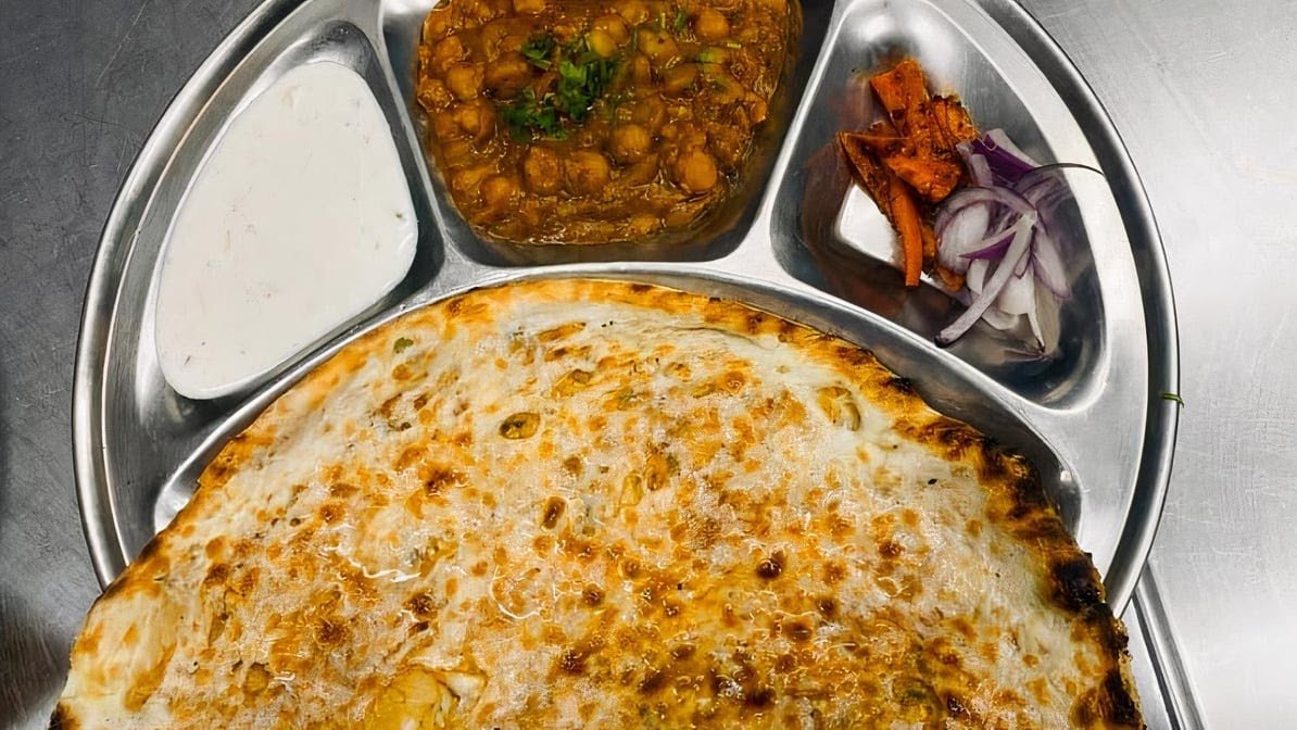 Authentic Amritsari Chana Kulcha Platter with chickpea curry, pickled onions and raita
